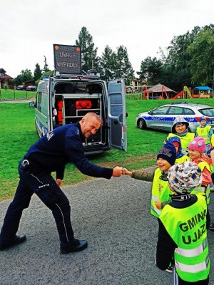 Zdjęcie przedstawia policjanta wraz z przedszkolakami.