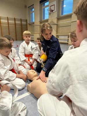 Zdjęcie przedstawia zajęcia z pomocy przedmedycznej z udziałem młodych karateków.