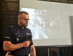 Zdjęcie przedstawia policjanta podczas prelekcji.