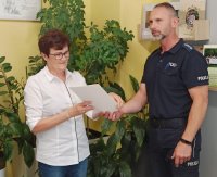 Dyrektor Publicznej Szkoły Podstawowej w Żędowicach odbiera list gratulacyjny z rąk policjanta